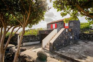 a house with a staircase and a red window at Adega Velha in Calheta de Nesquim