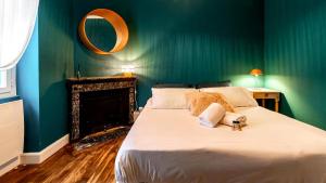 a bedroom with a large bed with a green wall at Gare Dijon - Cour Petite Loge in Dijon