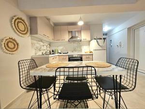 a kitchen with a table with chairs and a refrigerator at Peacock House in Amfilochia