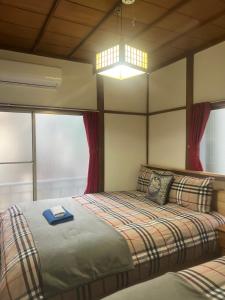 a bedroom with a bed with a book on it at 板橋 - 三国居Guest House in Tokyo