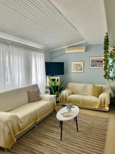a living room with two couches and a table at Evangeo Seaview Apartment Epanomi in Epanomi