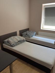 two beds in a room with a window at Domki przy siłowni in Siechnice