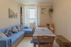 a living room with a blue couch and a table at Casa Azzurra, Vivi il Centro a due Passi dal mare in Portoferraio