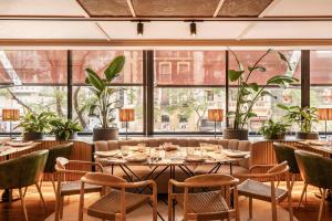 a dining room with tables and chairs and large windows at Vincci Soma in Madrid