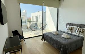 a bedroom with a bed and a large glass window at Elysian Blue villa 3 in Paphos City +23 photos