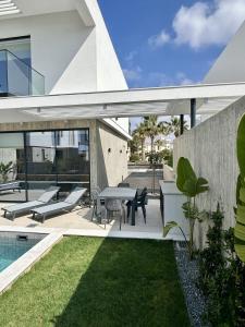 an external view of a house with a patio at Elysian Blue villa 3 in Paphos City