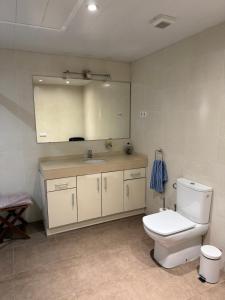 Un baño con un inodoro blanco y un lavabo. en La Llum de Sitges, en Sitges