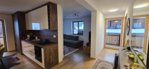 a kitchen and living room with a couch in a room at Poku bajka in Kranjska Gora