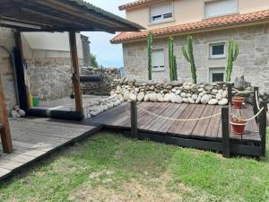 a backyard with a wooden deck and a house at Casa da Miniña in Quilmas