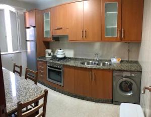 a kitchen with a sink and a dishwasher at Casa da Miniña in Quilmas