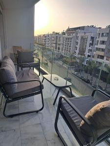 een balkon met stoelen en een tafel en uitzicht op de stad bij Studio ALMASSIRA in Casablanca +18 foto's