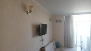 a living room with a couch and a tv on the wall at Sea Star in Batumi