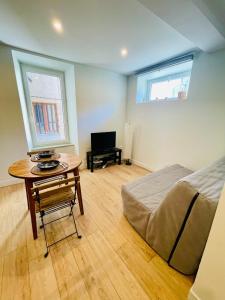 een slaapkamer met een bed, een tafel en een bureau bij Studio L'Émeraude in Tournon-sur-Rhône