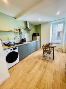 een keuken met een tafel, een wastafel en een fornuis bij Studio L'Émeraude in Tournon-sur-Rhône