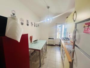 a kitchen with a white counter and a red refrigerator at CASA BARBARA in Ventimiglia