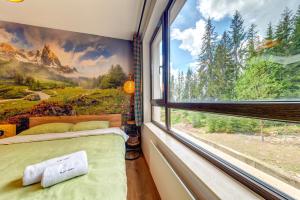 een slaapkamer met een raam met uitzicht op de bergen bij Into the Woods - Charming Studio by Flat Manager in Smolyan