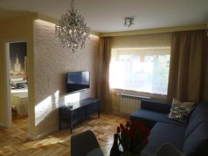 a living room with a blue couch and a television at Studio Plac Bankowy in Warsaw