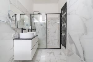 Un baño blanco con ducha y lavabo. en Appartamento in Duomo - Piatti, en Milán