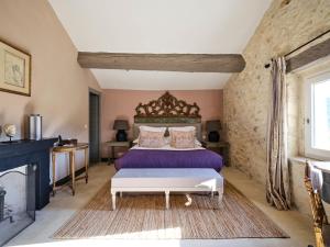 a bedroom with a large bed with a wooden headboard at Villa Syrah, La Bastide de Marie, Villa avec services in Ménerbes