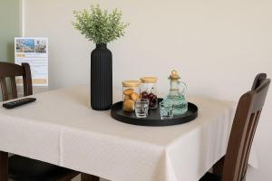 a table with a black vase and a tray with drinks at Nicolas Beach in Palaiochora