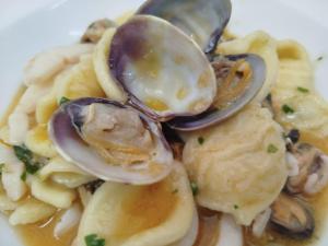 a plate of pasta with mushrooms and a spoon at Stella Maris Hotel in Ginosa Marina +15 photos
