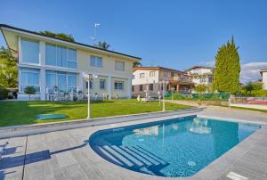 a swimming pool in front of a house at Desenzano Lakeview - Luxury Flat in Desenzano del Garda