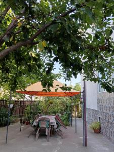 a table and chairs under an orange umbrella at Vila Prahoveană in Eforie Nord