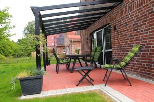 a patio with chairs and a table and awning at Sielentium in Greetsiel