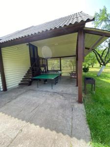 a pavilion with a ping pong table in front of a house at Садиба Оберіг 2 in Sheshory