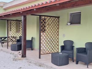 a pergola with chairs and a table on a patio at Agriturismo Pira Pinta in Dorgali