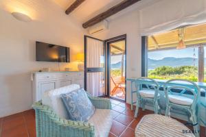 a living room with a couch and chairs and a balcony at Villa Margherita - By Searly in Porto Rotondo