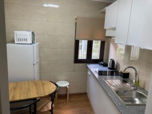 a small kitchen with a white refrigerator and a table at Refugio de Moncorvo in Torre de Moncorvo