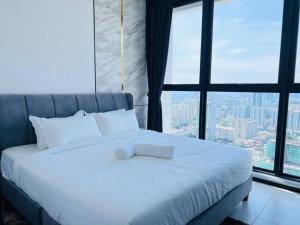 乔治市Urban Suites Georgetown Penang - Sea View & Georgetown View - High Floor - Exclusive & Cozy Stay的卧室配有白色的床和大窗户