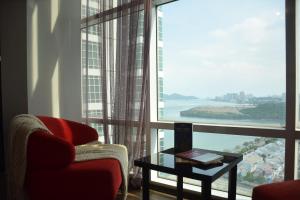 a living room with a chair and a table and a large window at Maritime Suite by Ocean Luxe 2BR Seaview Dryer Water Dispenser in George Town