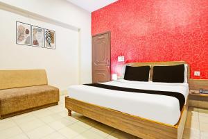 una camera con un letto e un divano di Super Hotel O Jaistambh Chowk Formerly Guru Kirpa a Raipur