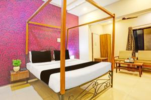 una camera da letto con un letto e una parete rosa di Super Hotel O Jaistambh Chowk Formerly Guru Kirpa a Raipur