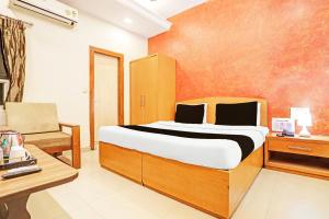 una camera da letto con un letto, una scrivania e una sedia di Super Hotel O Jaistambh Chowk Formerly Guru Kirpa a Raipur
