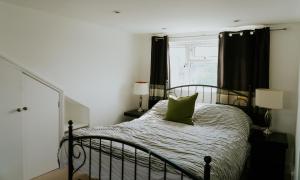 a bedroom with a bed with a green pillow on it at Station House in Horsham
