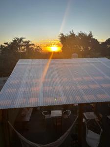 Un grupo de paneles solares con una puesta de sol al fondo. en Apart clemencia, en Puerto Iguazú
