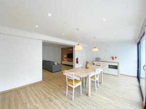 Una cocina y un comedor con mesa y sillas. en Casa Trevo de 4 Folhas, en Furnas