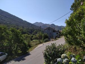 an empty road with a house and mountains in the background at Casa do Poeta in Bubaces
