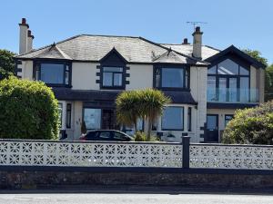 a house with a white fence in front of it at "SUPERB-SEA-VIEWS"ROOM ONLY at WETHERBY NAIRN in Nairn