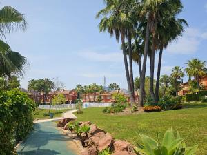 a path through a park with palm trees and grass at La Casita de Monte Biarritz by Lica in Estepona