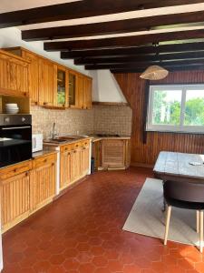 a kitchen with wooden cabinets and a table and a window at Les Combres in La Daguenière