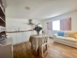 a kitchen and living room with a table and a couch at GRUPO GONTAD CASA CARMUCHA in Graña