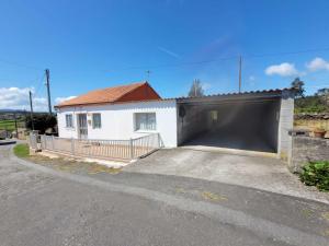 a white garage with a large black garage door at GRUPO GONTAD CASA CARMUCHA in Graña