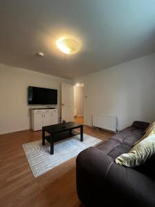 a living room with a couch and a coffee table at Lovely 2 bedroom Back Hilton near PJ Live in Aberdeen
