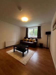 a living room with a couch and a table at Lovely 2 bedroom Back Hilton near PJ Live in Aberdeen +4 photos