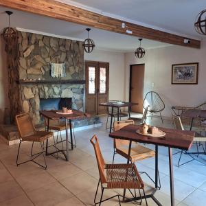 a dining room with tables and a stone fireplace at La Genoveva Posada entre Viñedos in Villa Unión