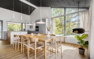Una cocina y un comedor con mesa y sillas de madera. en Cozy Home In Knebel With Sauna, en Ørby